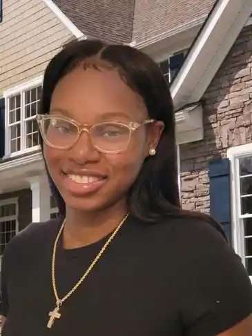 A woman wearing glasses and smiling for the camera.