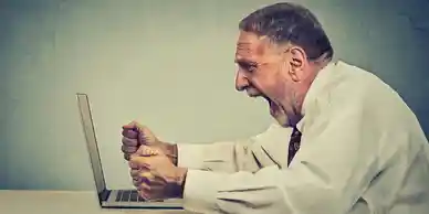 A man sitting at a table with his hands in the air.