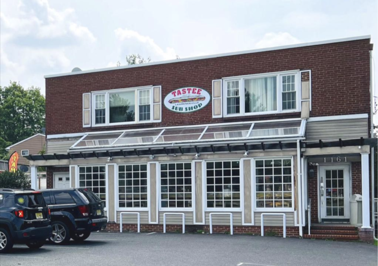 A car parked in front of a building with windows.