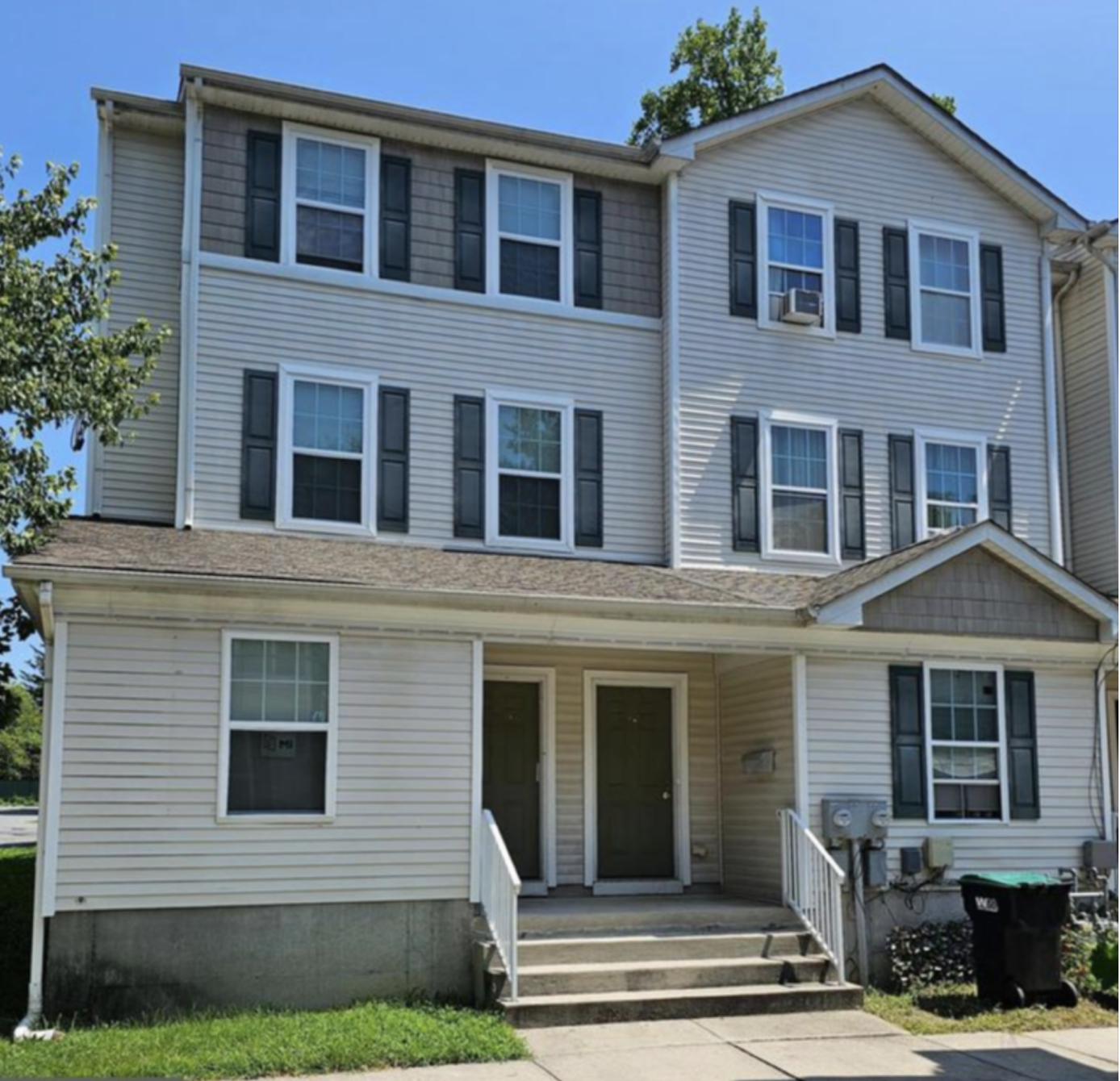 A large white two story house with black shutters.